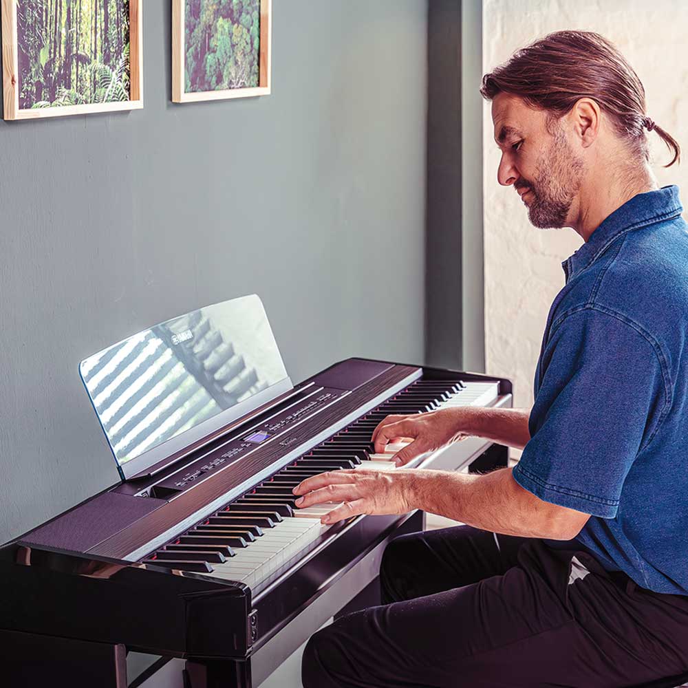 Yamaha P-525 Digitalpiano in Schwarz Mann spielt