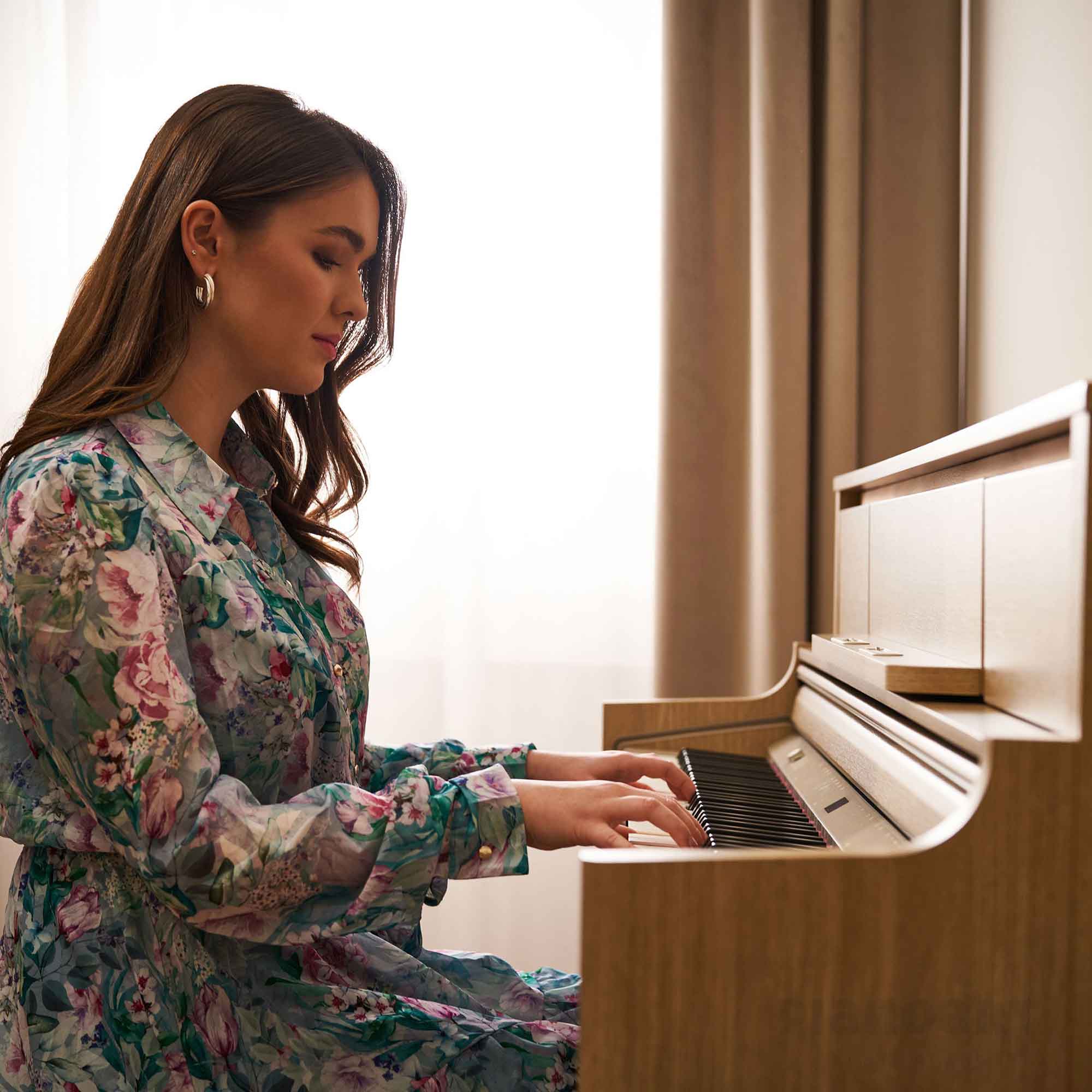 Frau im Wohnzimmer spielt auf Roland Digitalpiano LX5 LA