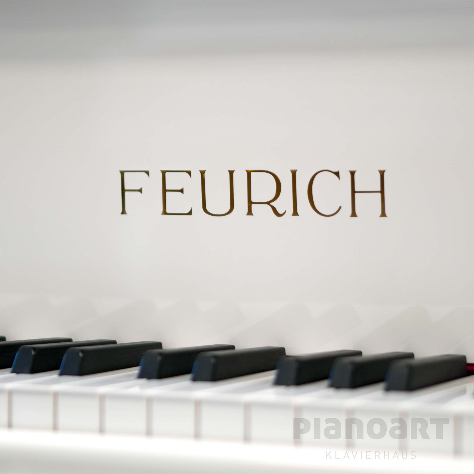 Feurich Logoprägung auf einem weißen Flügel